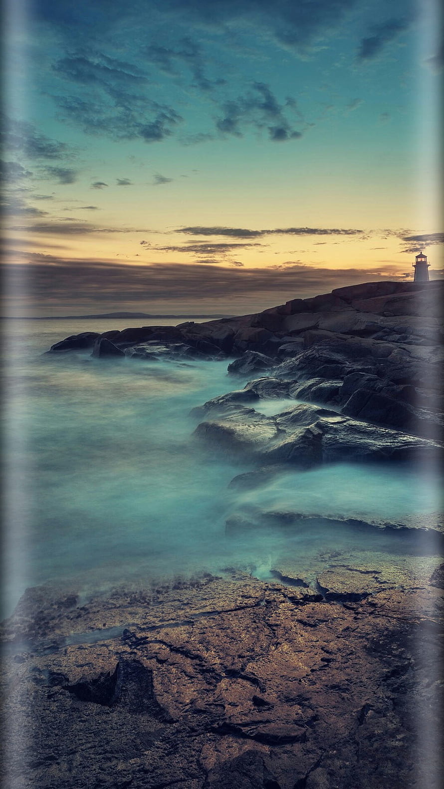 Serene Lighthouse on Rocky Coastline with Misty Ocean Waves at Sunset HD phone wallpaper