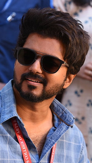 Dhanush wearing sunglasses and a blue plaid shirt with a red lanyard HD phone wallpaper