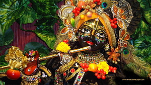 Ornate Black Krishna Idol Playing Flute with Peacock Feathers and Floral Jewelry HD wallpaper