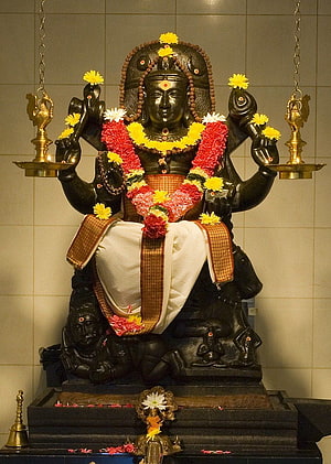 Black Stone Statue of Hindu Deity Ayyappan with Flower Garlands and Oil Lamps HD phone wallpaper