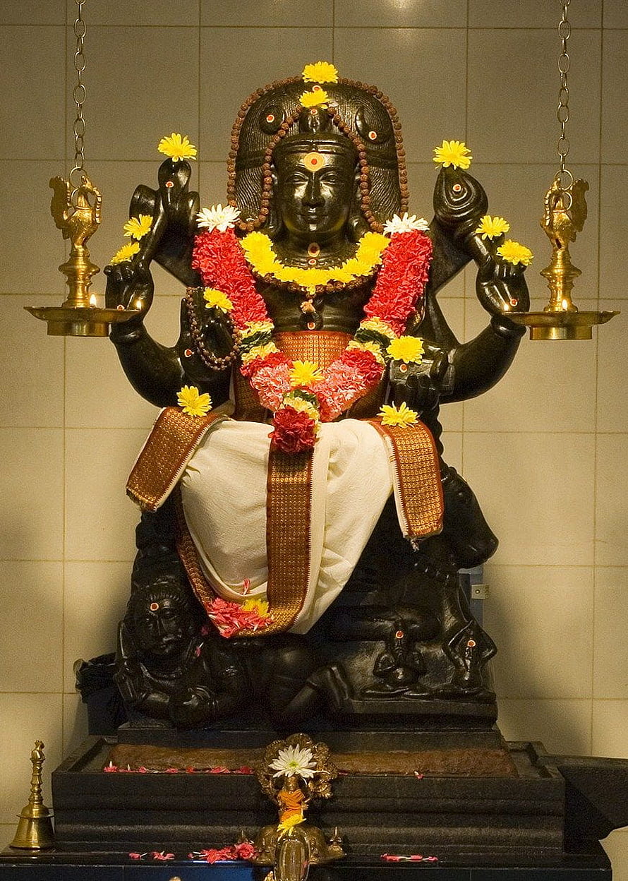 Black Stone Statue of Hindu Deity Ayyappan with Flower Garlands and Oil Lamps HD phone wallpaper