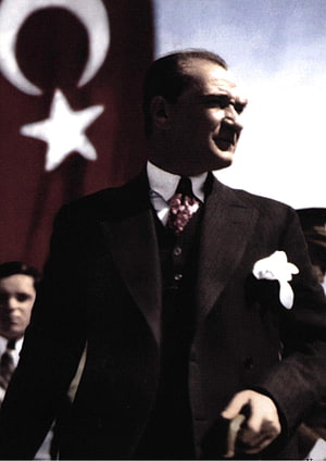 Mustafa Kemal Ataturk standing in a suit with the Turkish flag in the background HD phone wallpaper