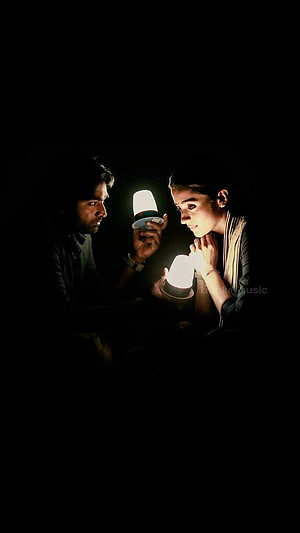 Ranbir Kapoor and Alia Bhatt in a dimly lit scene from the movie Brahmastra holding glowing orbs HD phone wallpaper
