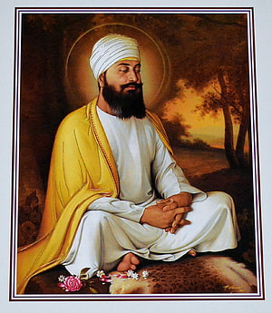 Sri Guru Nanak Dev Ji sitting in meditation with a golden halo and yellow shawl HD phone wallpaper