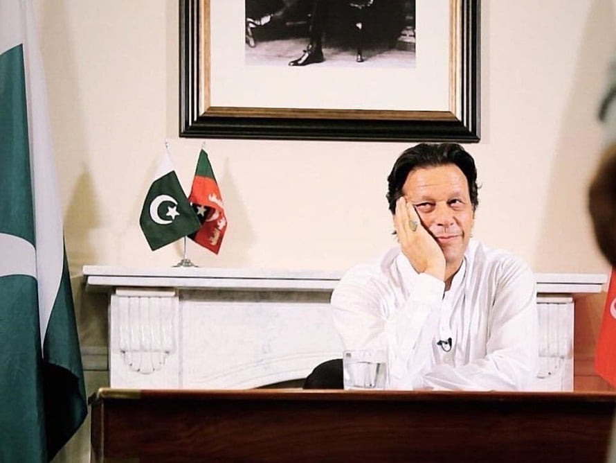 Imran Khan sitting at a desk with Pakistan and Afghanistan flags in the background HD wallpaper