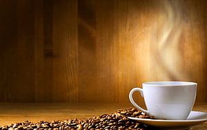 Steaming White Coffee Cup with Roasted Beans on Warm Wooden Table HD wallpaper