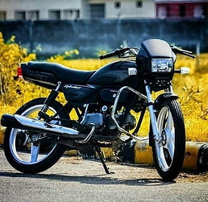 Black Splendor Motorcycle Parked on Road with Yellow Flowers HD wallpaper