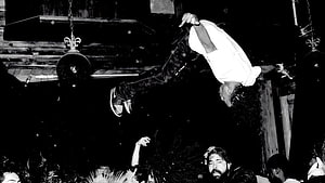 Playboi Carti performing an acrobatic flip over the crowd at a live concert HD wallpaper